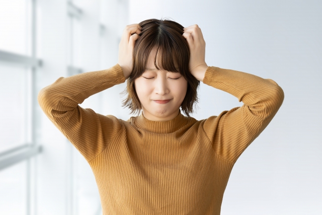 感情がコントロールできずに頭を抱える女性。