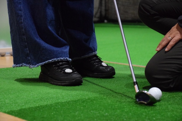 ゴルフのボール位置を微調整している。