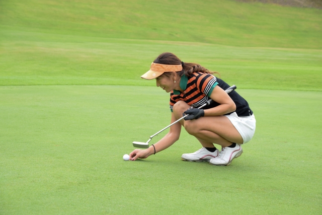 ゴルフのマーカーを置く女性。